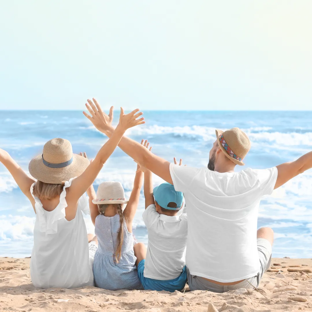 Familie sitzt am Strand.