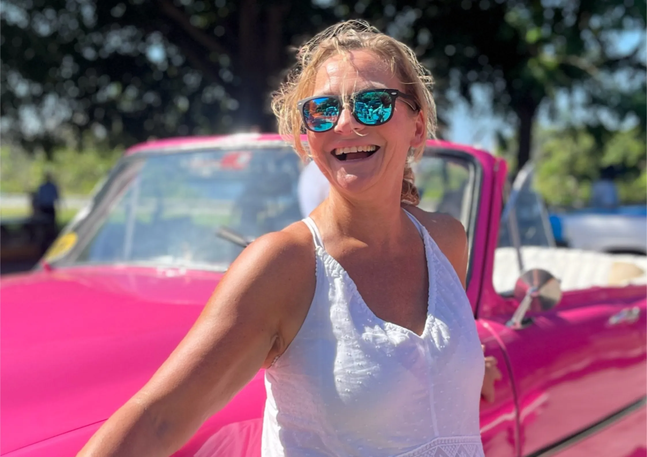 Bettina Zwickler in Havana vor einem pinken Oldtimer