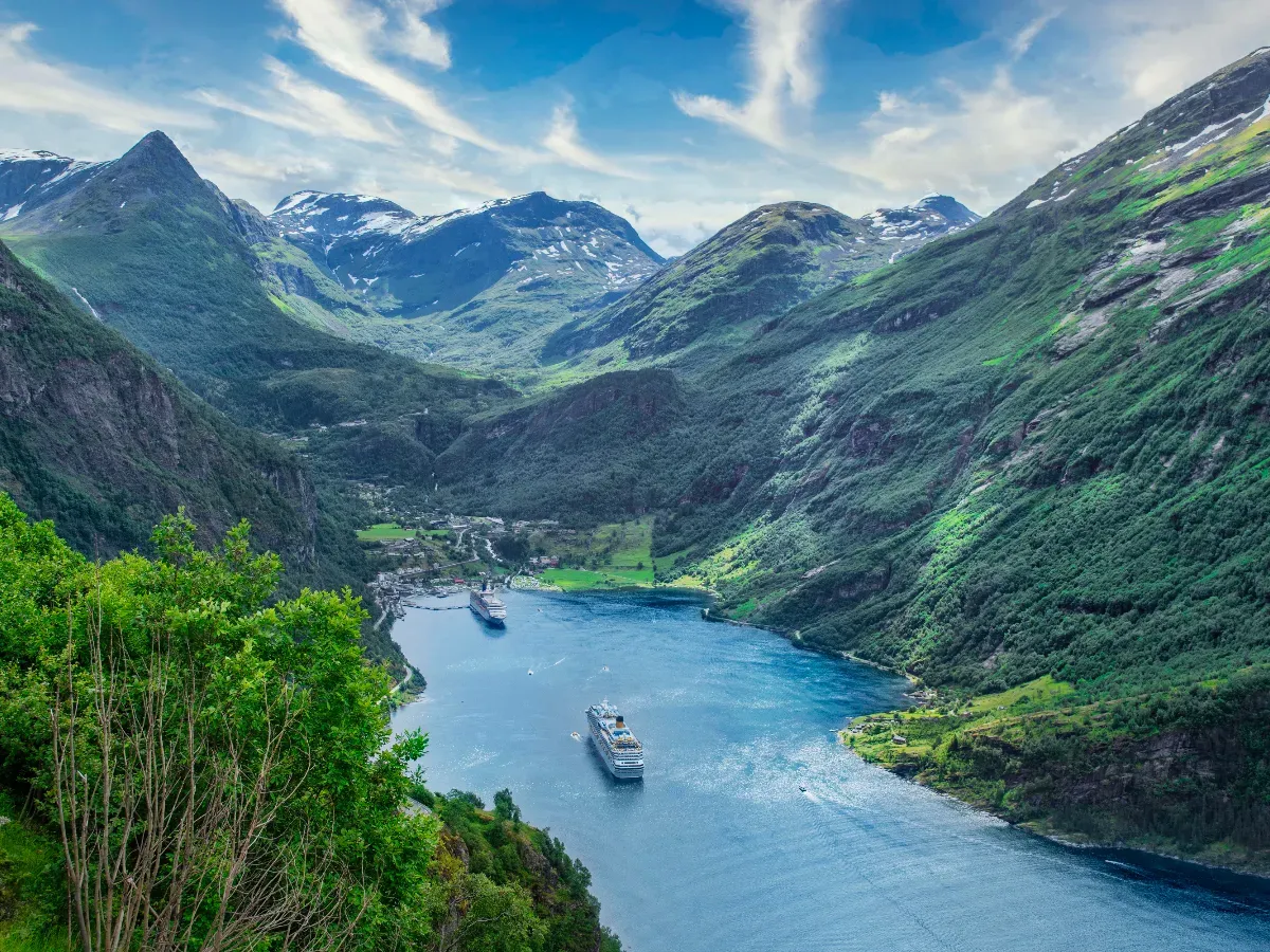 Zwei Kreuzfahrtschiffe aus der Vogelperspektive in einem Fjord, von hohen Bergen umgeben